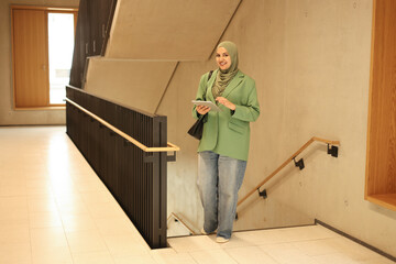 Confident Muslim woman walking at college campus.
