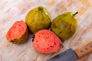 Fresh juicy whole and sliced guava fruits on wooden table. Healthy vitamin product..