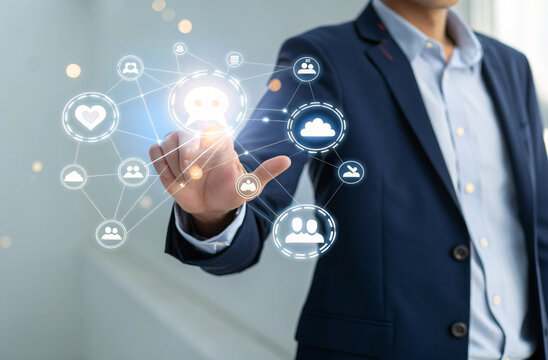 "Modern tech visualization of a businessperson interacting with a holographic communication interface. Chat bubbles, emojis, and social media icons float above their hand in a glowing web. Person wear - Powered by Adobe