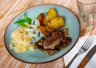 Rabbit liver dish with boiled potatoes and sauerkraut