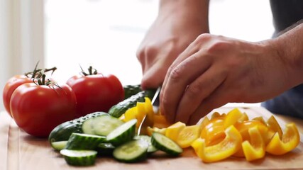 4K food prep clip of hands chopping cucumbers peppers and tomatoes on a kitchen surface Great for cooking videos healthy eating or meal prep content - Powered by Adobe