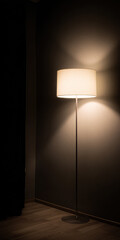 A floor lamp turned on near a wall in a dark room. Warm light creates soft shadows and a cozy ambiance. Minimalist interior in Scandinavian style.