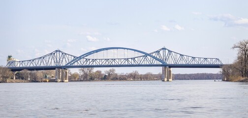 Naklejka premium Steel Arch Bridge Over Calm River
