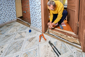 Plumber uses two open end wrenches to tighten securing nuts of compression coupling on multilayer...