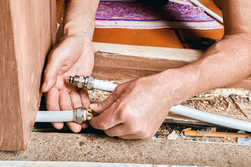 Plumber positions compression ring onto multilayer pipe as part of fitting assembly to prepare...
