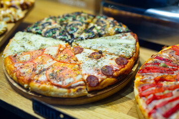 Delicious pizza on wooden table. several slices of different pizza flavors
