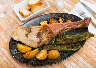 Baked lamb shoulder with potatoes, peppers and eggplants at a restaurant