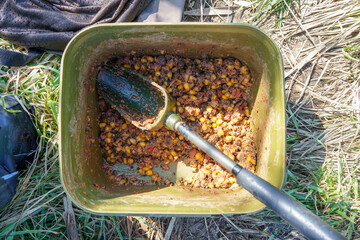 corn, hemp, and pellets mixed in a bait box at the fishing spot before baiting