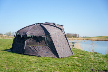 fishing spot with a carp tent pitched on the shore of the reservoir, Poland