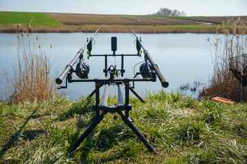 tripod with fishing rods at a fishing spot on the shore of the reservoir, Poland