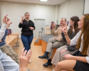 A group of young people talking in sign language. 