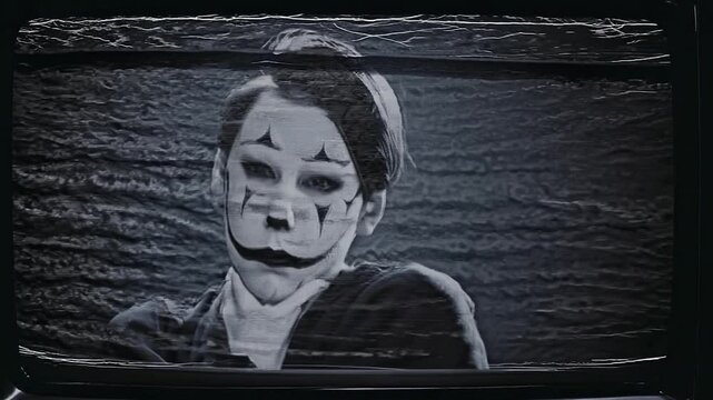 Disturbing images of a young woman wearing clown makeup appearing on a flickering, noisy old television screen create a chilling and suspenseful atmosphere