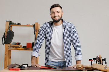 Portrait small owner business, Caucasian young adult male tailor in workshop with leather materials