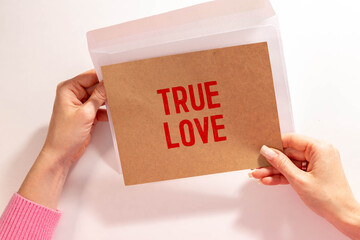 The text True Love appearing behind torn brown paper.