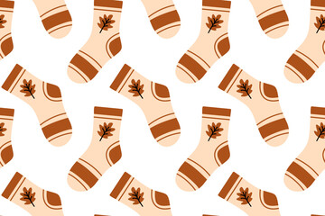 Warm seamless pattern featuring beige autumn socks with brown leaf details for seasonal designs