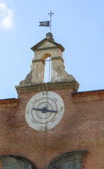 Close up view of the clock on the red brick wall on top of the Sinopie Museum entrance door in...
