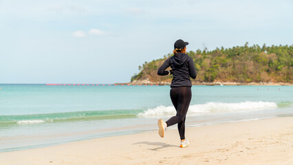 Healthy Asian woman in sportswear jogging exercise on tropical beach. Sporty girl enjoy outdoor active lifestyle sport training fitness workout running at seaside. Wellness healthcare sport motivation