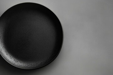  Minimalist black plate on textured gray background, perfect for culinary or restaurant branding visuals