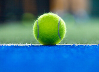Padel ball on court during sunny day, clean and minimalistic image for sports websites, blogs, and promotional materials.