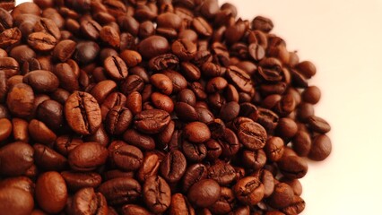 Aromatic Pile CloseUp of Roasted Coffee Beans on Cream Background.