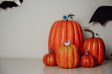 spooky, funny and moody copy space halloween banner with pumpkins, eye candies and bats in the...