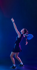 Padel. Fit woman preparing to serve with padel racket in modern glowing light representing action strength and fitness dedication