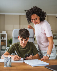 Mother and teenage boy do some homework together at home