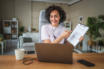 woman work from home wearing headset talk with client on video call