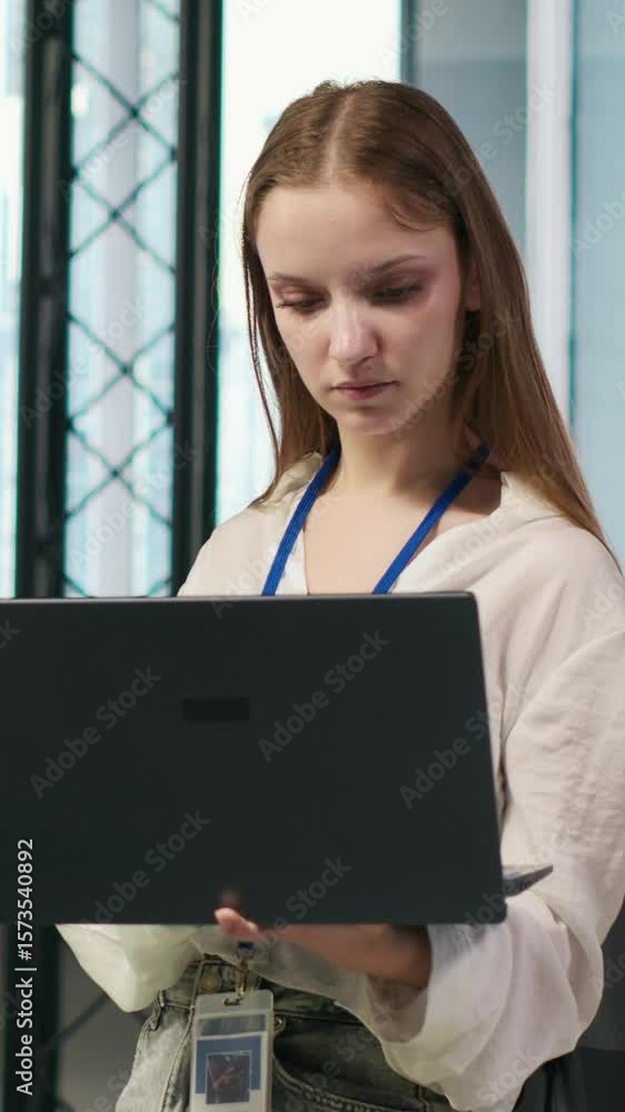 Fototapete vertical video portrait of young smiling female programmer in office automating repetitive tasks usi