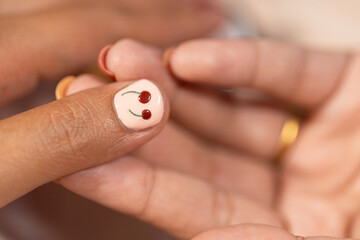 Nail art with cherry design on thumb nail reflects beauty and fashion trends in home nail salon treatment for stylish and creative self care