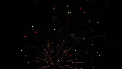 Firework exploding crowns with shimmering traces and sparks in black sky. Vivid firework flashes on...