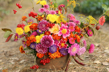 Beautiful autumn pink yellow orange red purple bouquet with dahlia, aster, marigold flower and colorful leaves. Fall flowers close up
