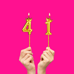 Hands holding number-shaped candles - Birthday number 41