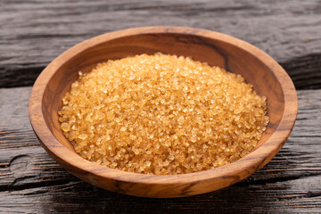 Organic brown sugar in a wooden bowl - Saccharum officinarum