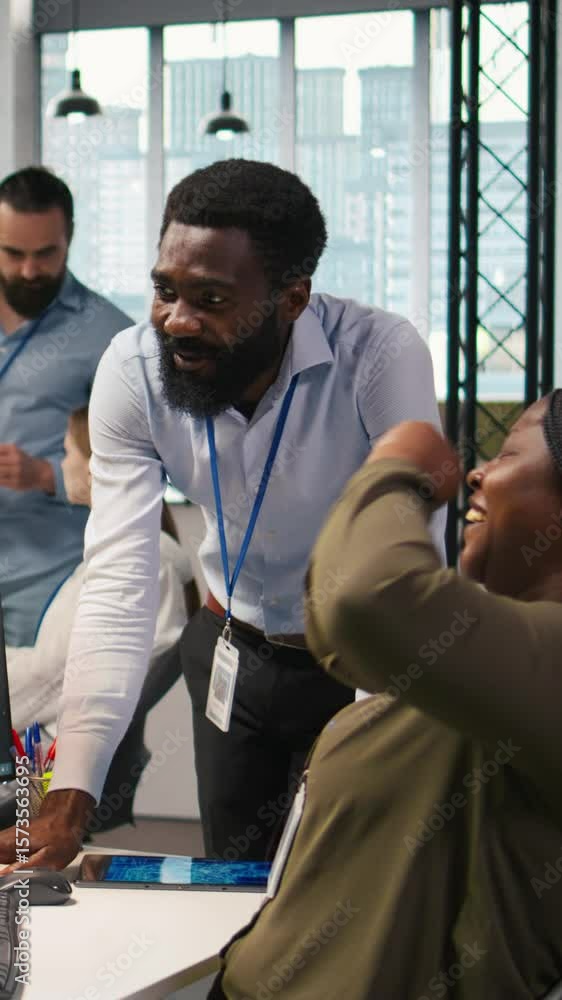 Poster vertical video cheerful programmers in office enjoying conversation while automating repetitive task
