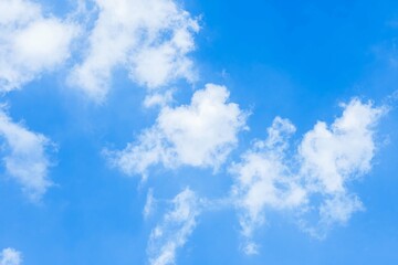 A beautiful bright blue sky filled with fluffy white clouds on a clear summer day