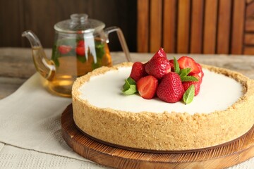 Tasty cheesecake with strawberries and mint on wooden table, closeup