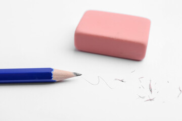 Pencil, eraser, doodle and scraps on white background, closeup