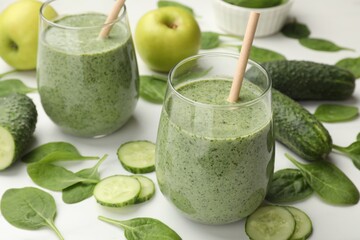 Tasty spinach smoothie and ingredients on white table, closeup