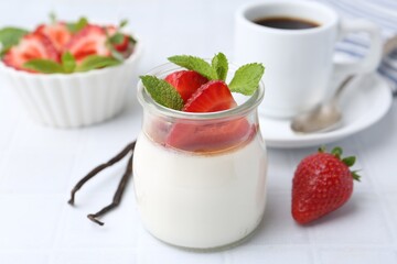 Tasty panna cotta with caramel, strawberries, mint, vanilla pods and coffee on white table, closeup