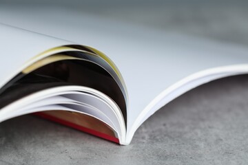 One open magazine on grey table, closeup