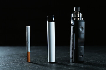 Electronic smoking devices and cigarettes on black table