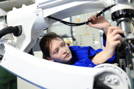 Female engineers checking or maintenance electronic in AI Robot, robot arm in the manufacturing automation and robotics manufacture room. - Powered by Adobe