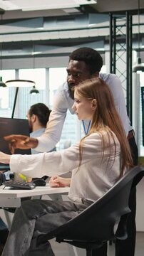 Vertical video Startup office manager congratulates young girl after developing artificial intelligence models for business analytics. Team leader doing fist bump with female engineers pleased by work