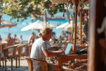 Person Working on Laptop at Beachside Cafe with Scenic View