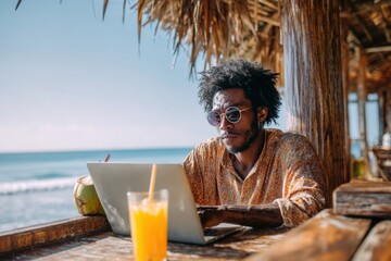 Relaxed Man Working on Laptop at Beachside Café with Drink