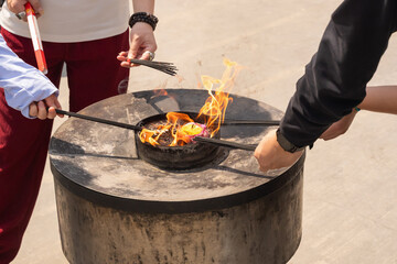 Buddhists burn incense during a religious ceremony at a temple in a peaceful setting