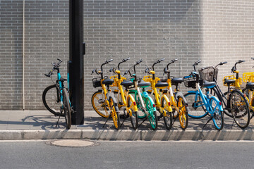 Colorful bicycles parked along a sidewalk in Shanghai on a sunny day