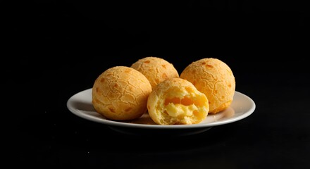 Delicious golden cheese bread rolls served on a white plate against a dark background a close up shot revealing the soft fluffy interior