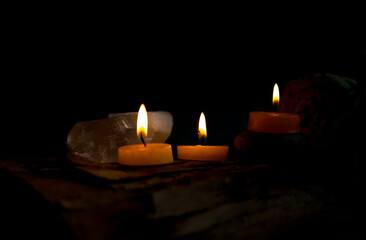 Velas encendidas con cristales en ambiente oscuro y relajante